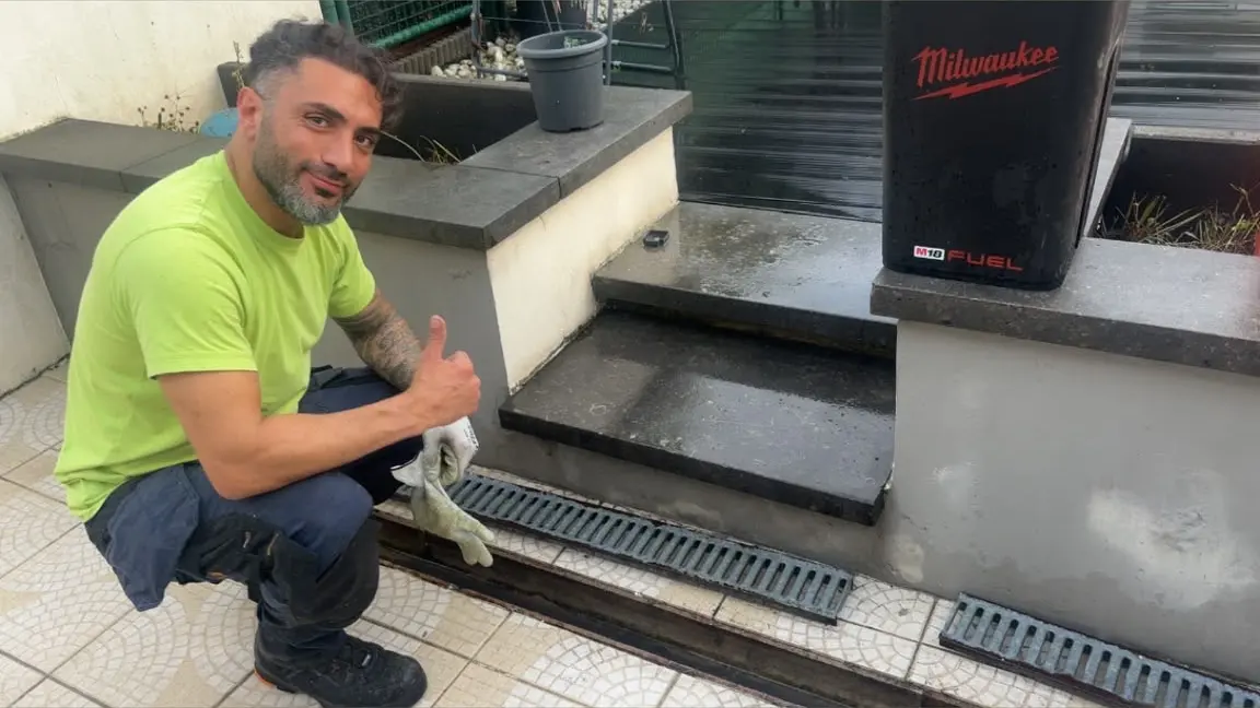 Caniveaux et avaloirs d'une cour bruxelloise nettoyés par un technicien HelpDrain, aspirateur de chantier en place