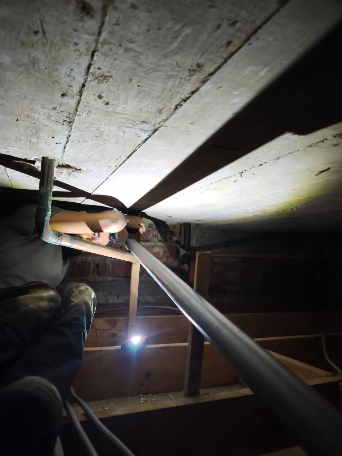 La nouvelle évacuation principale fixée sous le plancher du vide sanitaire, maison à Uccle